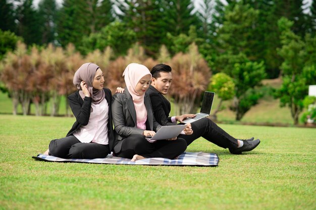 Young woman using mobile phone while sitting on tree