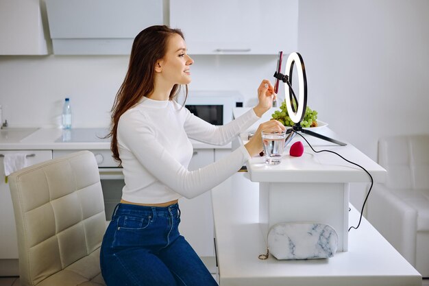 Photo young woman using mobile phone while standing at home