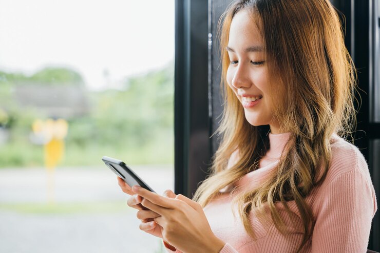 Photo 携帯電話を使っている若い女性