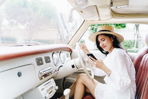 Young woman using mobile in a road trip