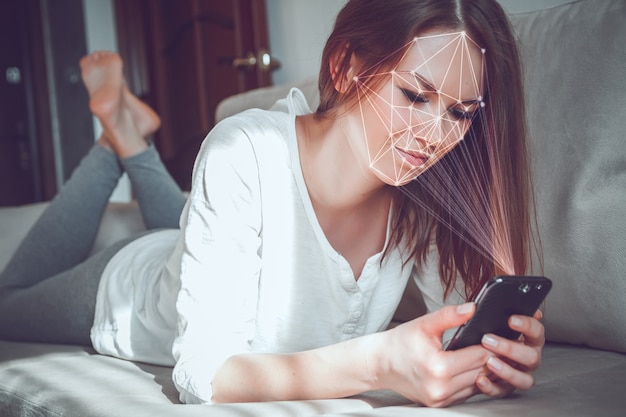 Young woman using new smartphone with face id technology