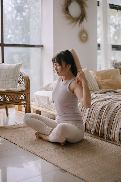 Photo young woman using phone while sitting on bed at home