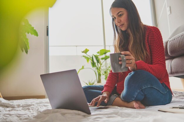 Photo young woman using phone while sitting at home