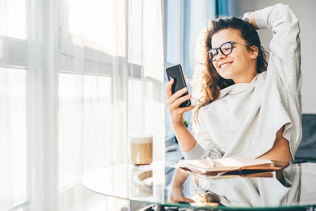 Young woman using phone while sitting at home