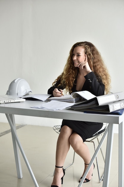 Фото Молодая женщина пользуется телефоном, сидя на столе.
