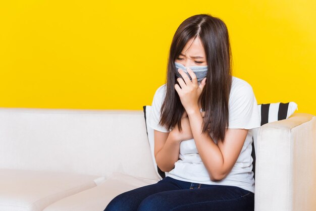 Young woman using phone while sitting on sofa