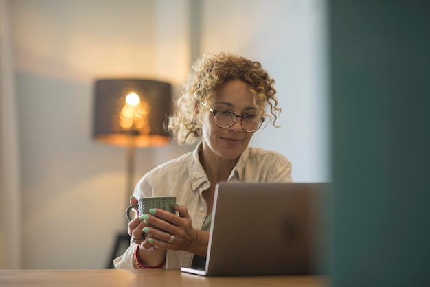 Photo young woman using phone while sitting on table