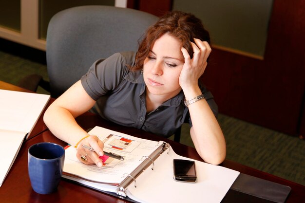 Young woman using phone while sitting on table