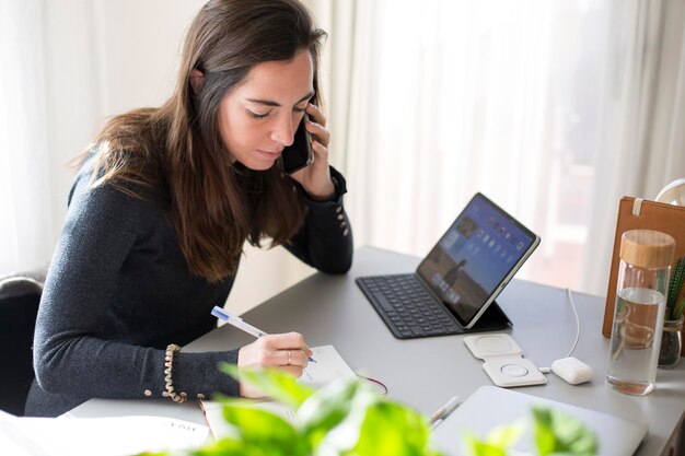 Young woman using phone while sitting on table