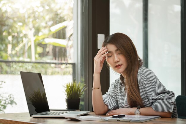 Photo young woman using phone while sitting on table