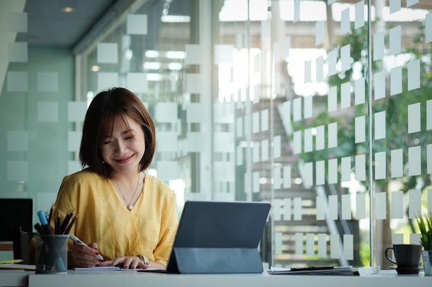 Photo young woman using phone while sitting on table