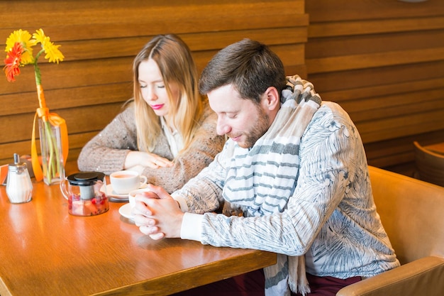 テーブルに座って電話を使っている若い女性