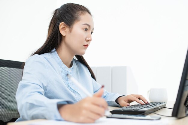 Young woman using phone while sitting on table