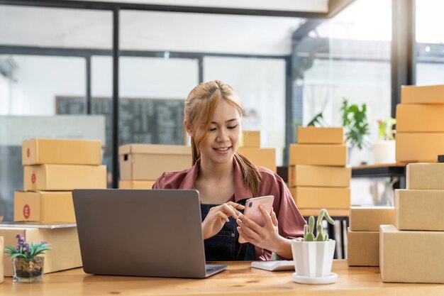 Young woman using smart phone while sitting at desk