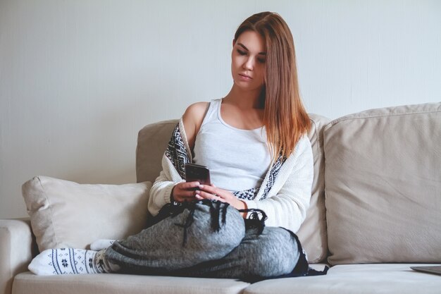 Young woman using a smartphone on a sofa