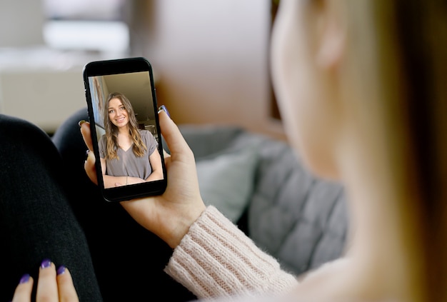 Giovane donna utilizza lo smartphone per la videochiamata. foto di alta qualità