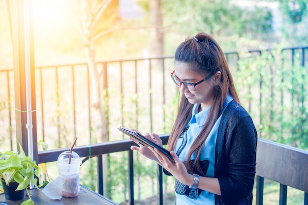 コーヒーショップでタブレットを使用している若い女性