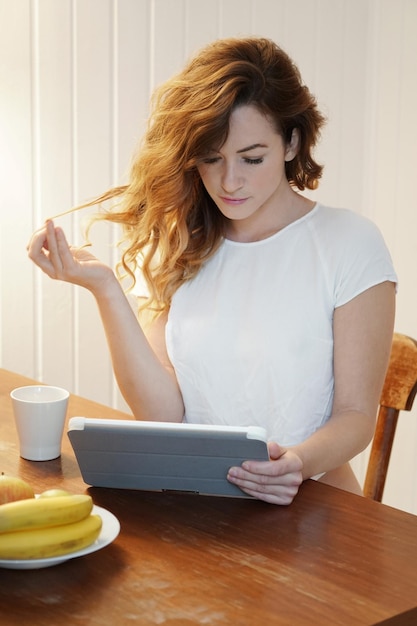 Young woman using tablet computer at home