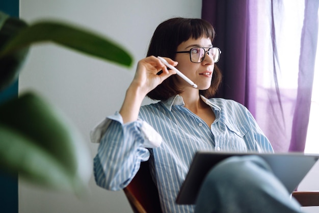 Young woman using tablet, spending leisure time chatting in social network.