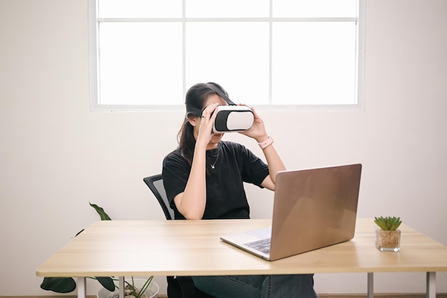 Young woman using Virtual Reality glasses at office room Education online studying video game