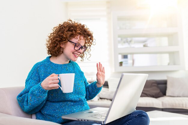 Young woman on a video call from home with her friends while in quarantine. Cropped shot of an attractive young woman using her laptop to make a video call at home