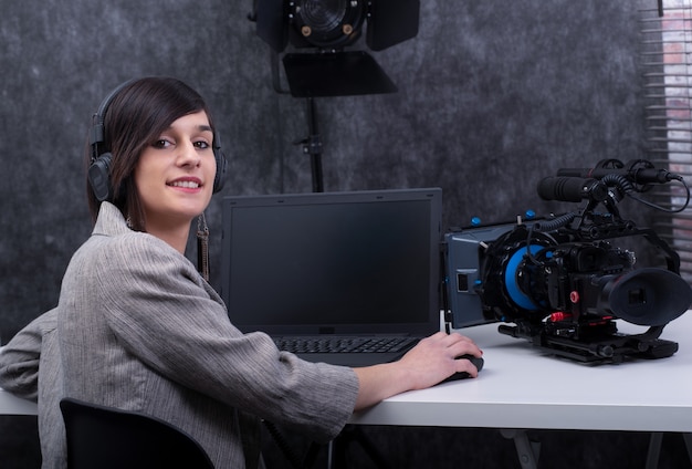 Young woman video editor working in studio