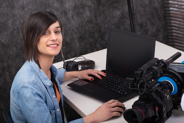 Young woman video editor working in studio