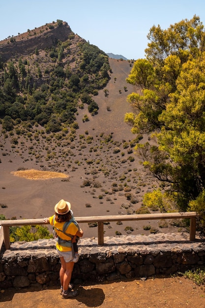 El Hierro Canary Islands의 La Llania 공원에 있는 Fireba 화산의 시점에 있는 젊은 여성 El Brezal 습한 숲 옆