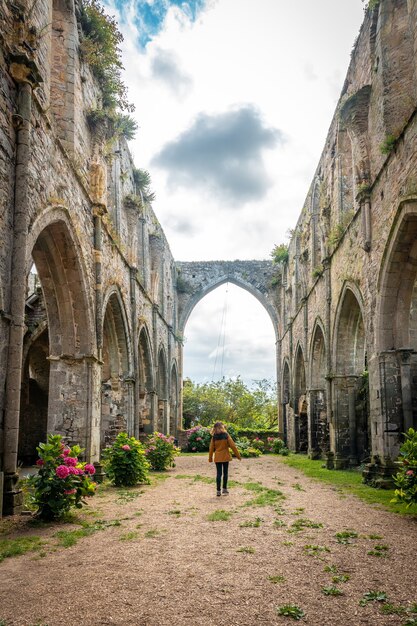 A young woman visiting the ruins of the Abbaye de Beauport church in the village of Paimpol, CÃÂ´tes-d'Armor department, French Brittany. France