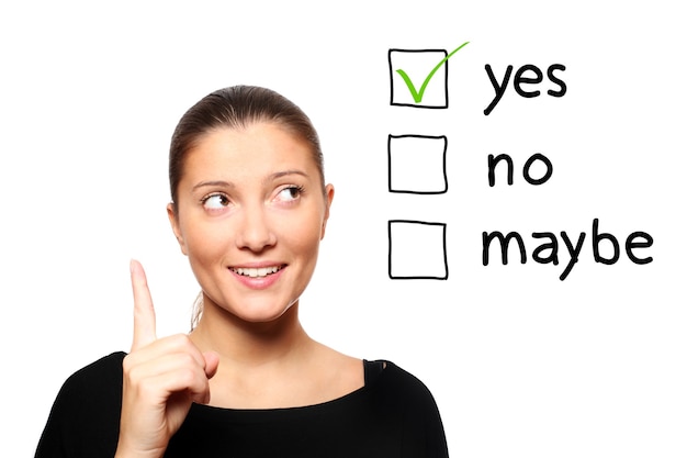 Photo a young woman voting for yes over white background