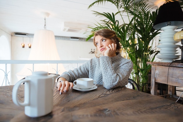 カフェで誰かを待っている若い女性