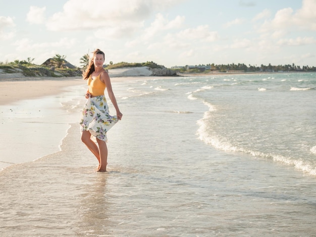 Young woman walking along the coast of the Atlantic Ocean. Close-up. Vacation and travel concept