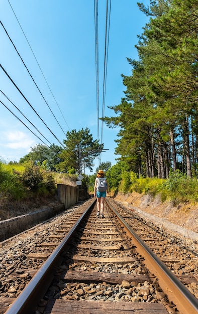 A young woman walking along the train tracks of Urdaibai, a Bizkaia biosphere reserve next to Mundaka. Basque Country