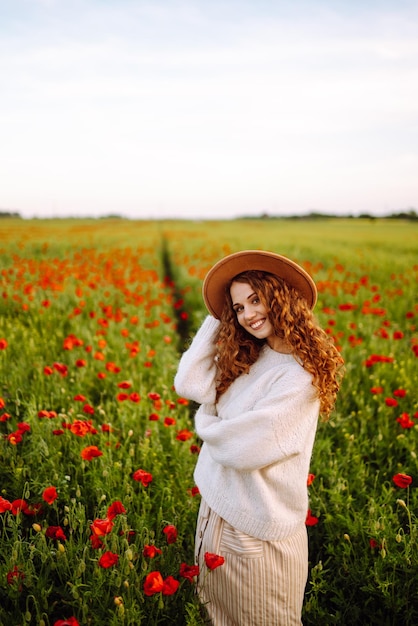 Young woman walking in amazing poppy field Nature vacation relax and lifestyle
