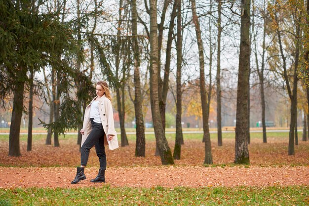 Foto giovane donna che cammina nella sosta di autunno