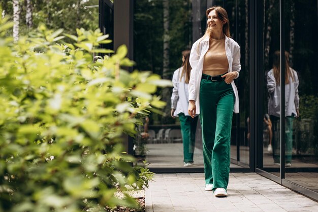 Young woman walking by the cafe located in park