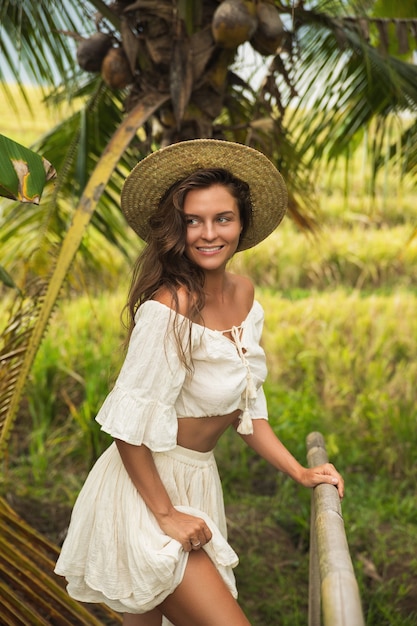 Young woman walking by old wooden bridge in the countryside