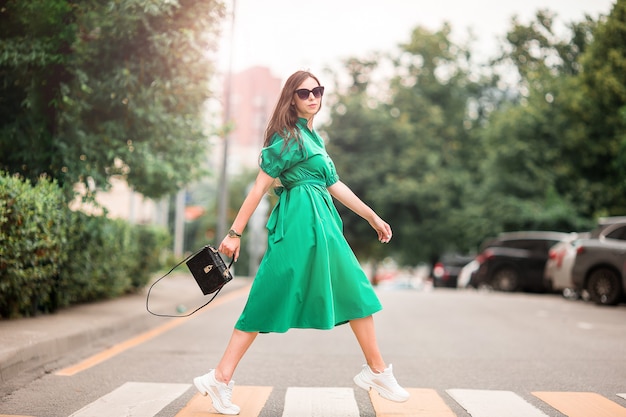 Young woman walking in the city across the street