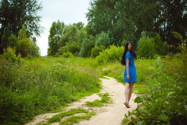 Foto giovane donna che cammina su una strada di terra nella foresta