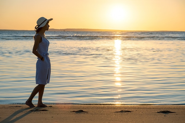 Young woman walking on empty sand beach