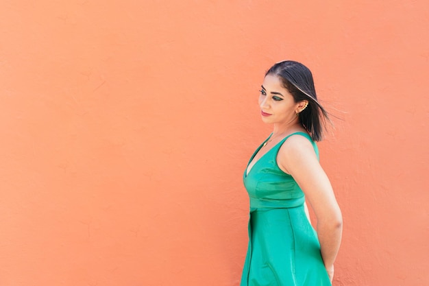 Young woman walking in front of red wall