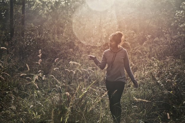 写真 森林の中を歩く若い女性