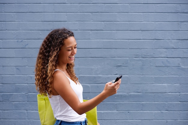 Young woman walking and looking at mobile phone