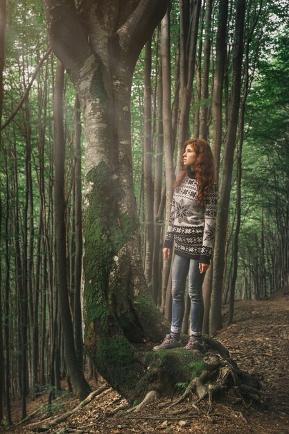 Giovane donna che cammina nella foresta magica