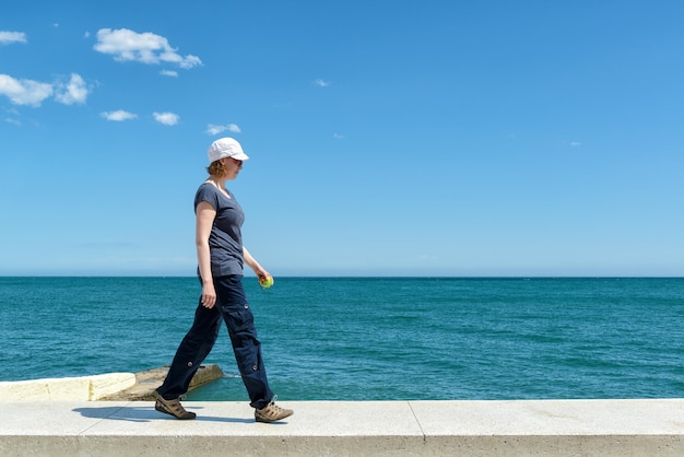 Alushta Crimea의 바다 산책로를 걷고 있는 젊은 여성