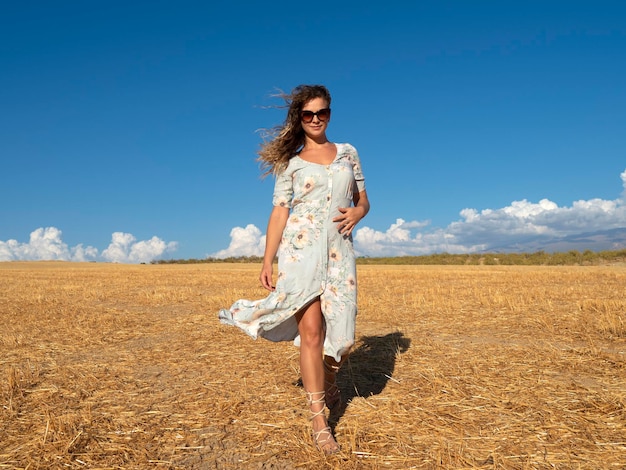 Young woman walking in sunny golden field