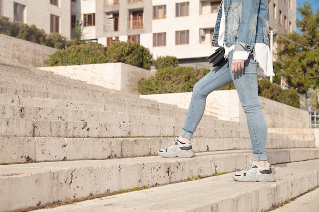 Young woman walking up the stairs in city.