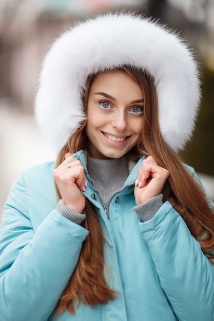 冬の公園を歩いている若い女性。雪の中のウィンターパーク。衣料品の広告写真のコンセプト。