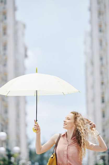 Young woman walking with parasol