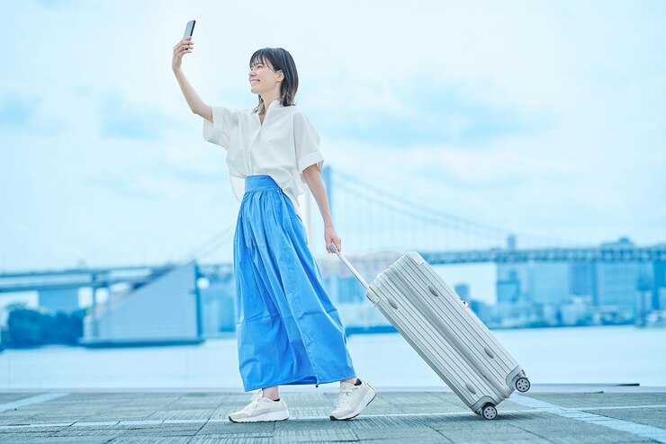 Photo スーツケースを持って歩く若い女性